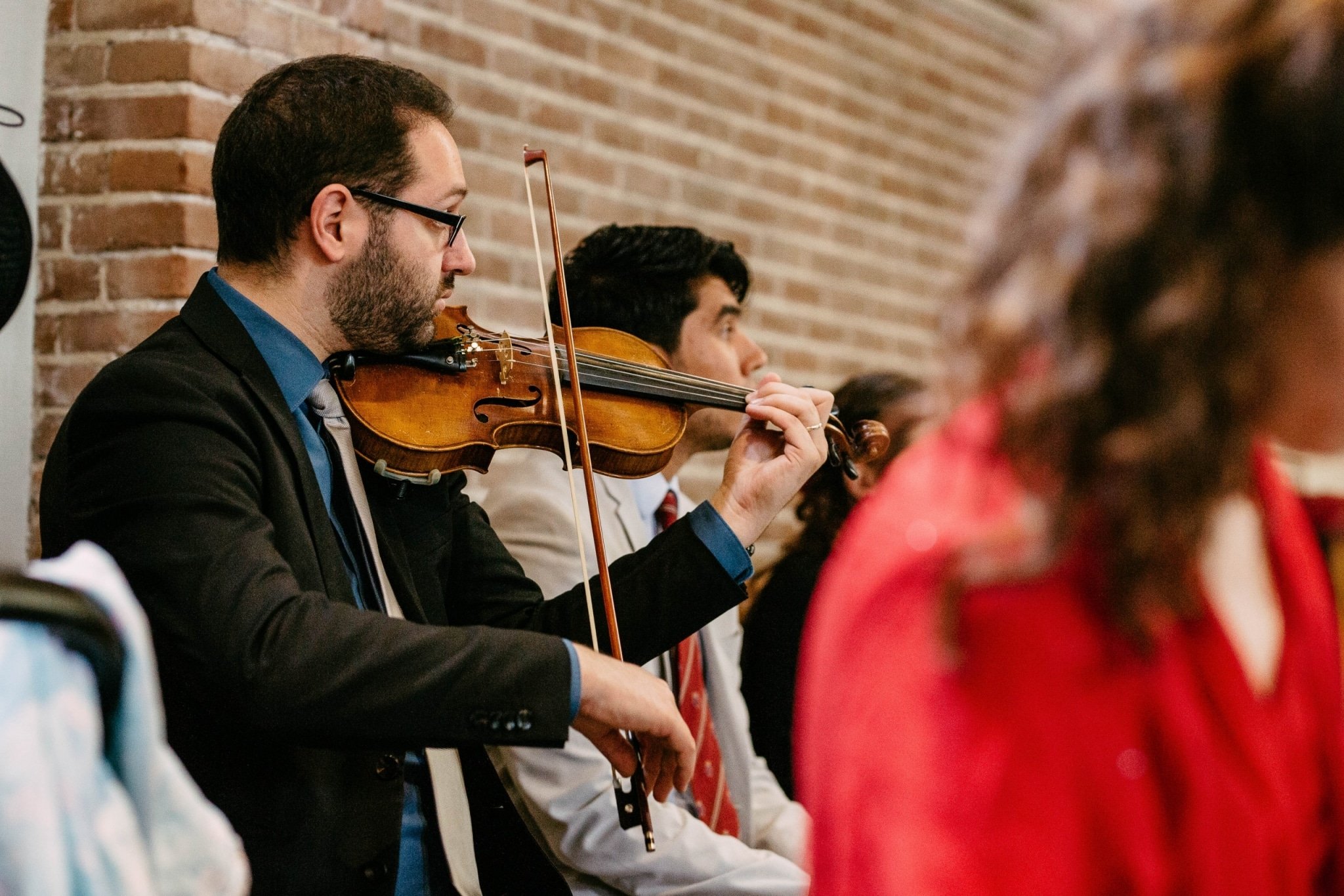 A man playing the violin for a group of people.