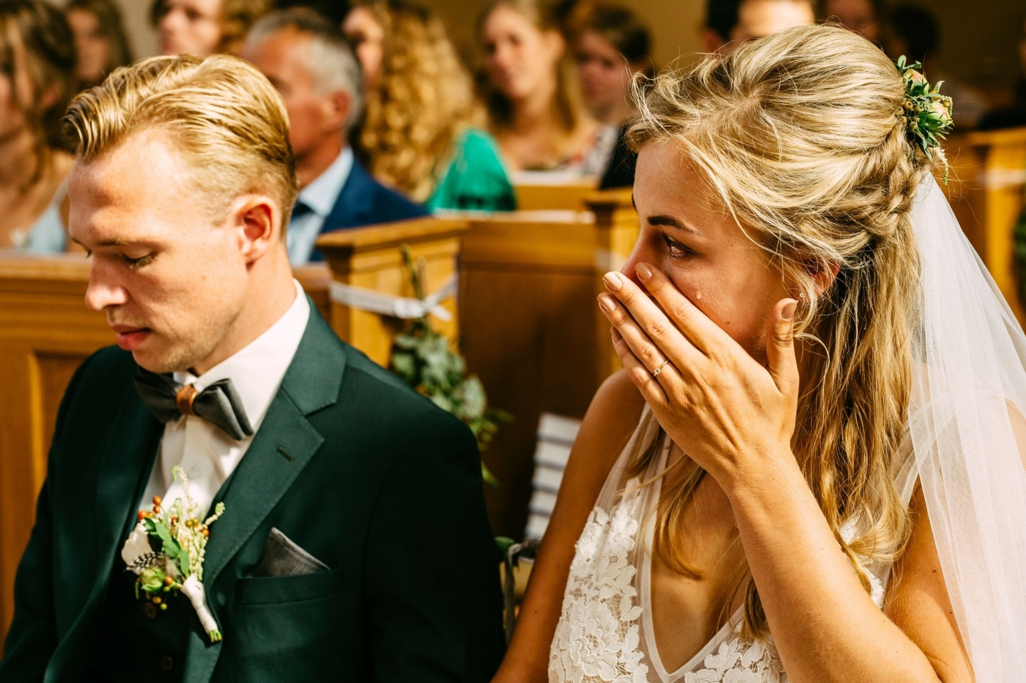 A bride and groom cry during their wedding ceremony.