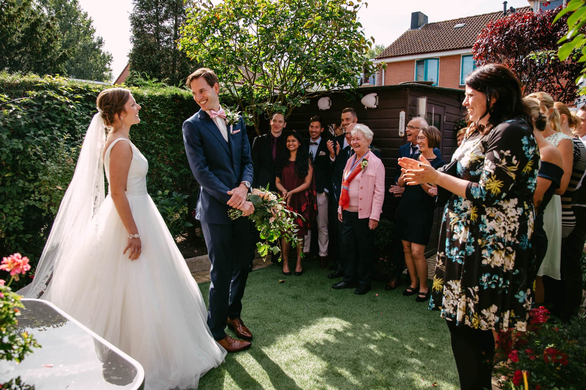 A wedding ceremony in a garden with a bride and groom.