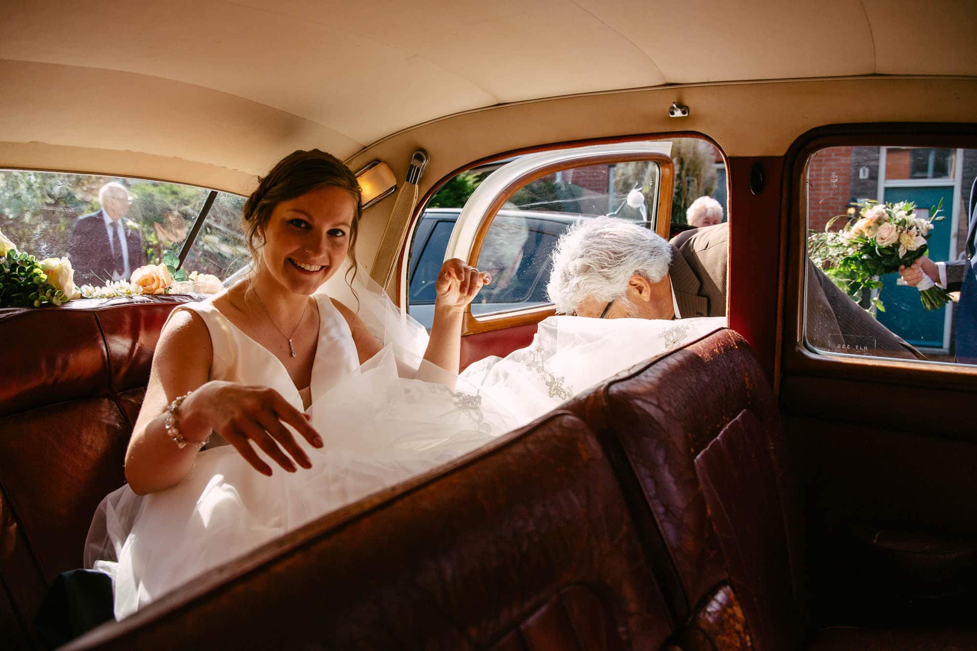 A bride in a vintage car with her mother.
