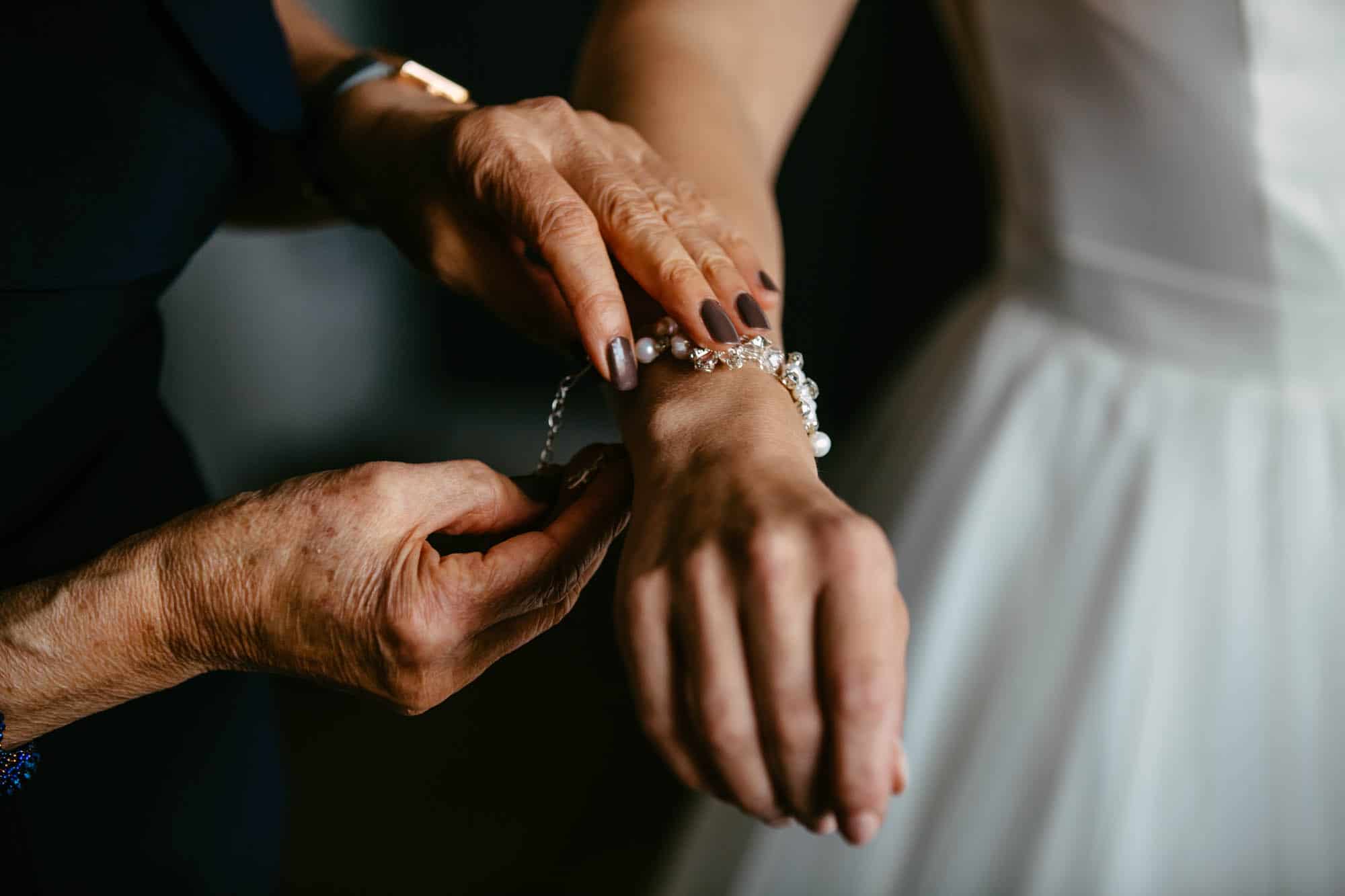 A woman puts on a wedding bracelet.
