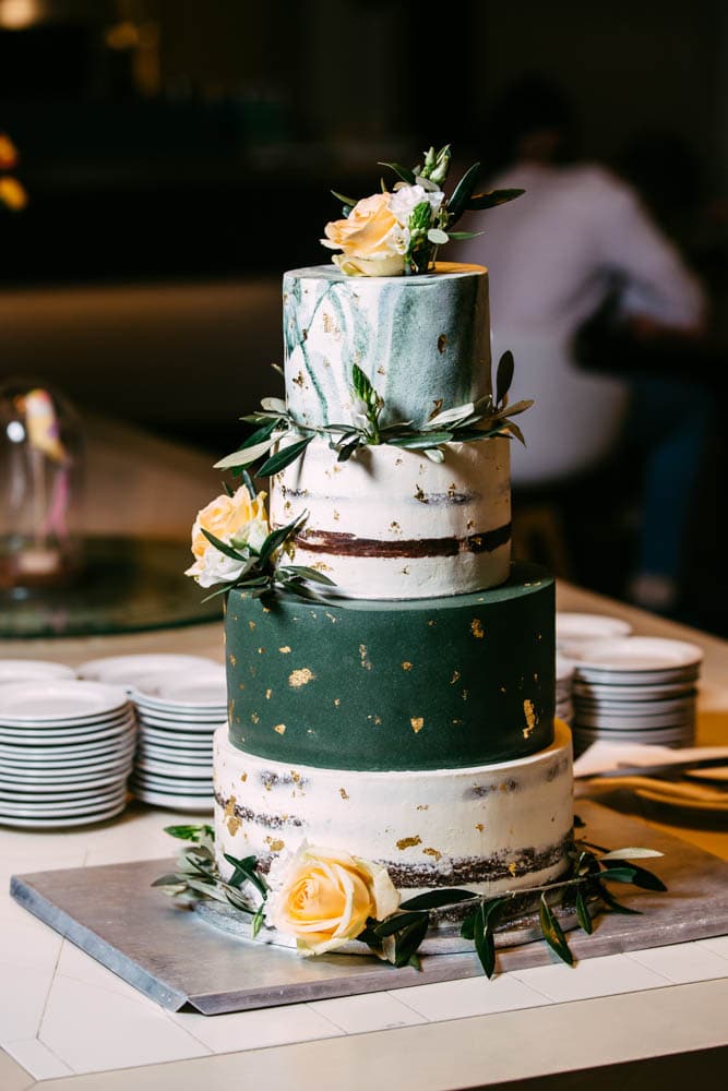 Description: A three-tiered wedding cake with flowers on top.