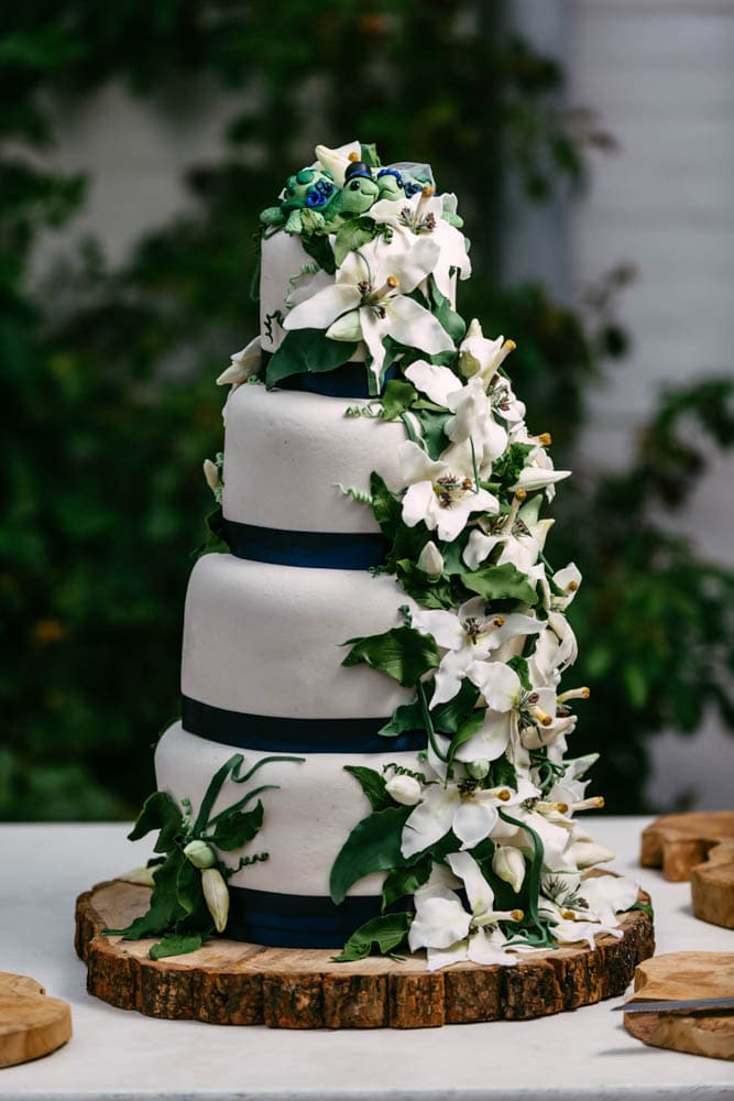 Een witte en blauwe bruidstaart op een houten tafel, dienend als bruiloftsinspiratie.