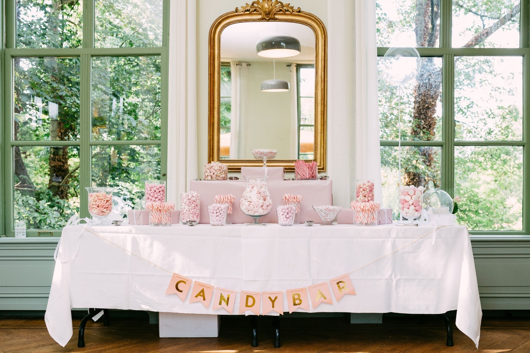 A candy-filled table with a sign for wedding inspiration.