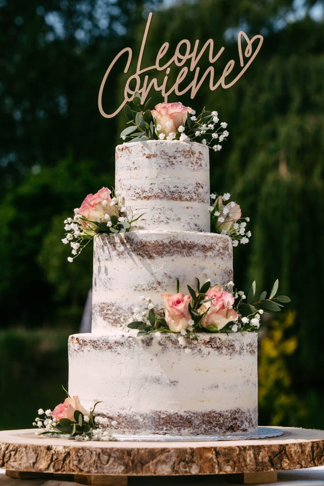 A wedding cake with a wooden plate on top.