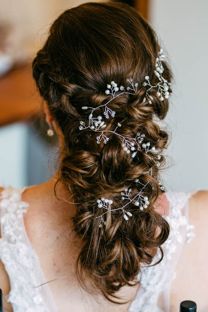 Het haar van een bruid versierd met prachtige bloemen, inspiratie voor een bruiloft.