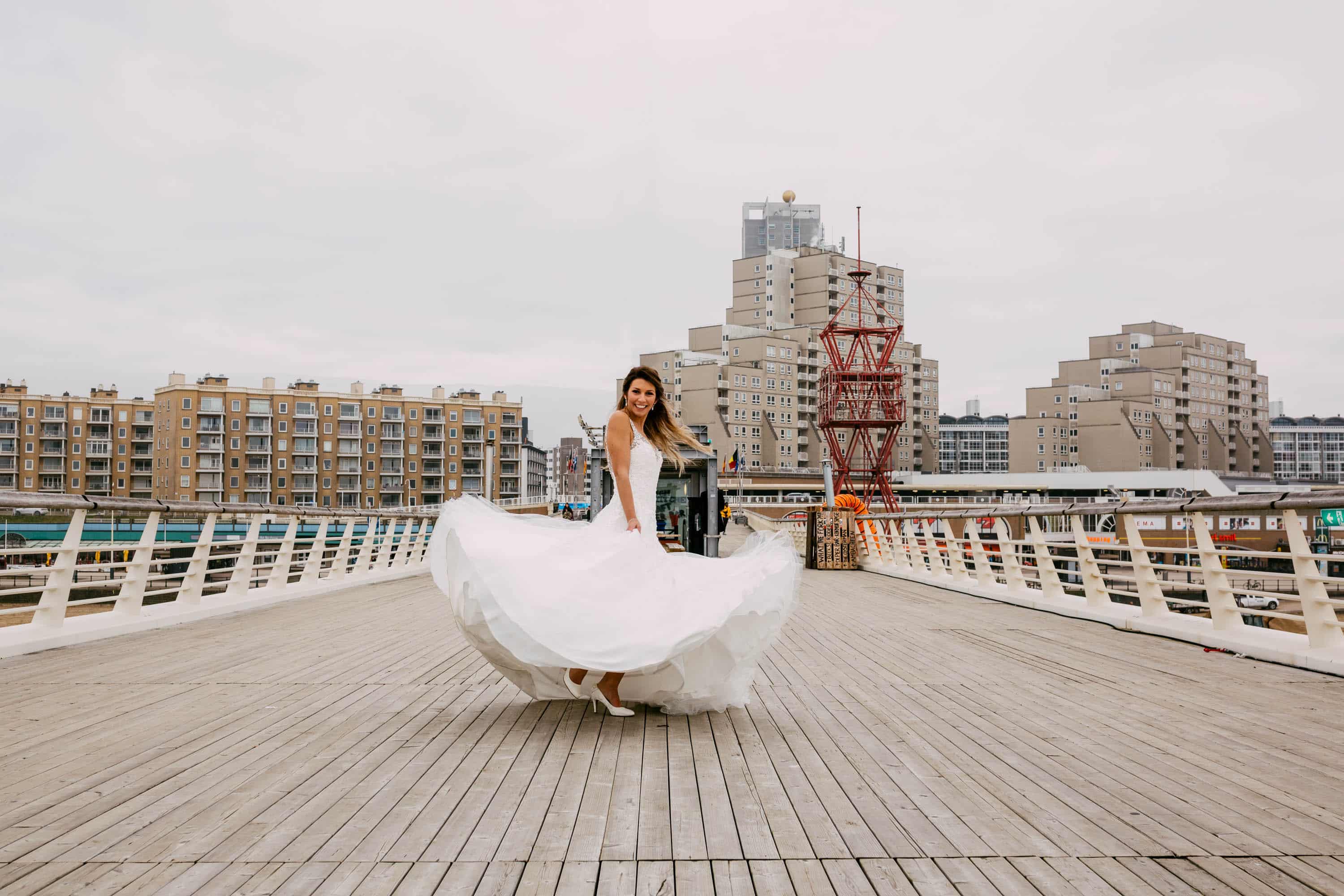 Een bruid in een trouwjurk die op een brug in New York loopt.