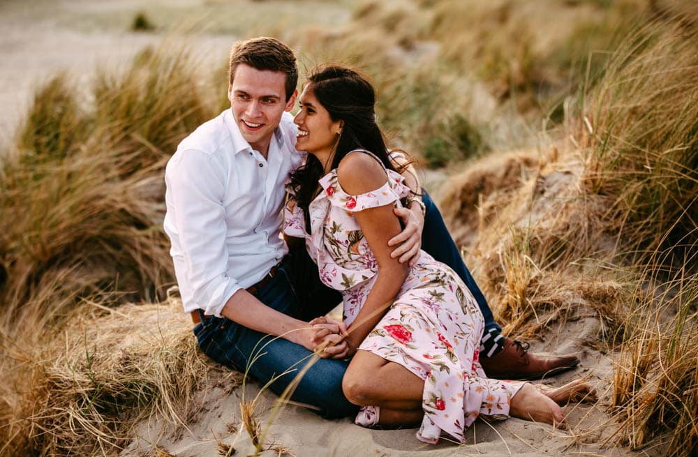 Een verliefd stel geniet van een romantische loveshoot op het zandstrand.