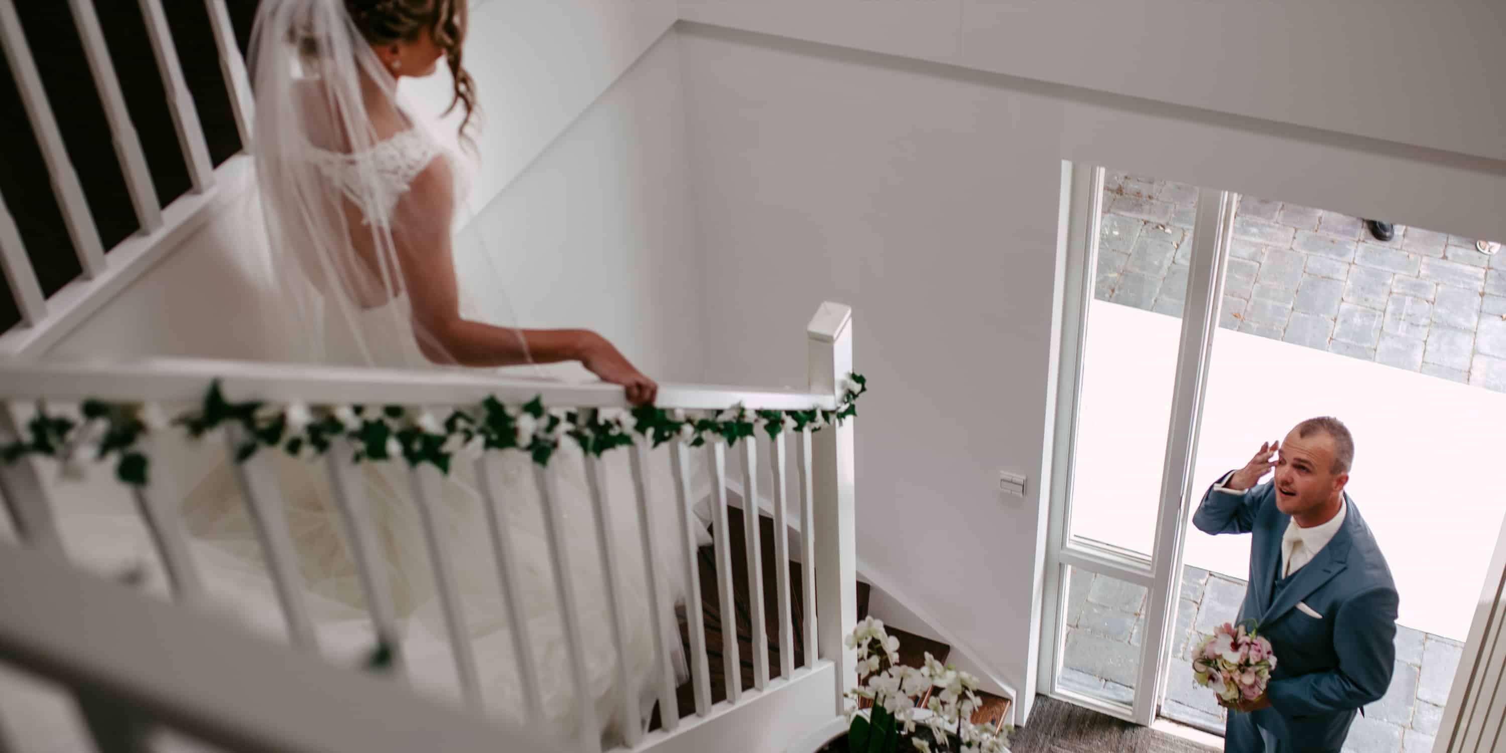 Een bruid en bruidegom staan op het CONTACT van een huis.