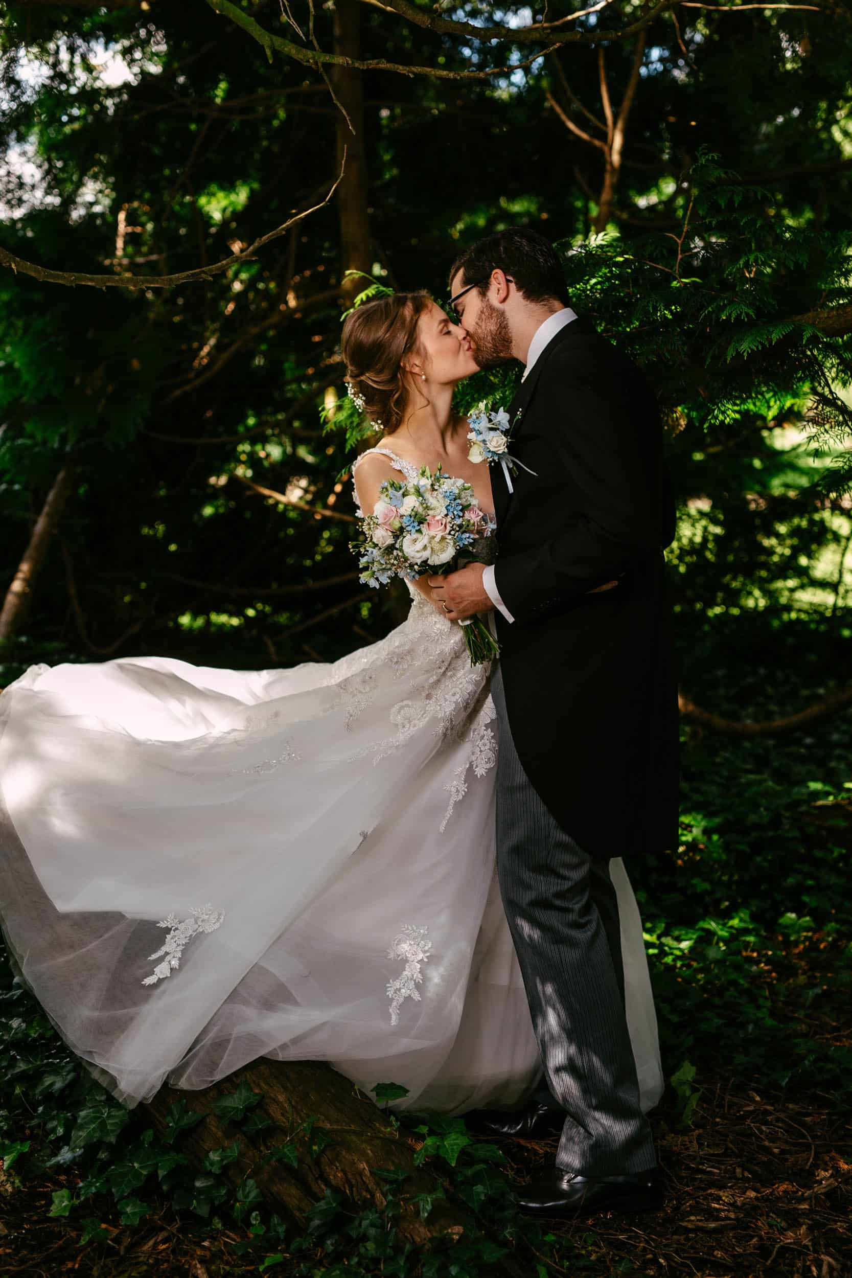 A bride and groom embracing amid the enchanting beauty of a botanical garden.