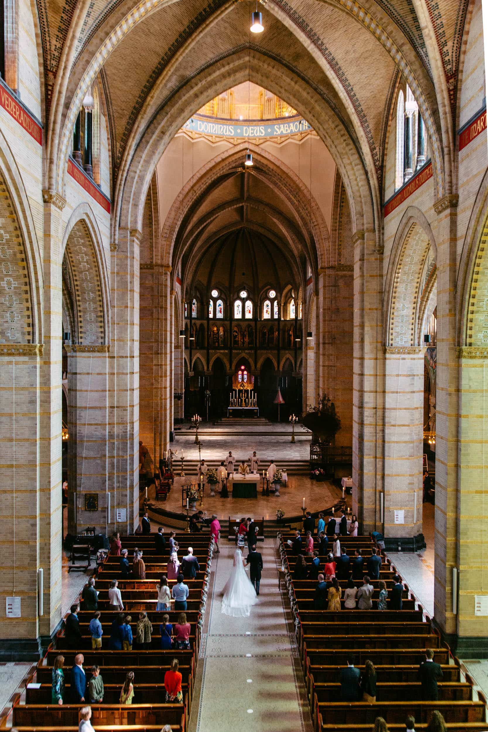 Een bruid en bruidegom die door het gangpad van een kerk lopen tijdens hun Trouwerijceremonie.
