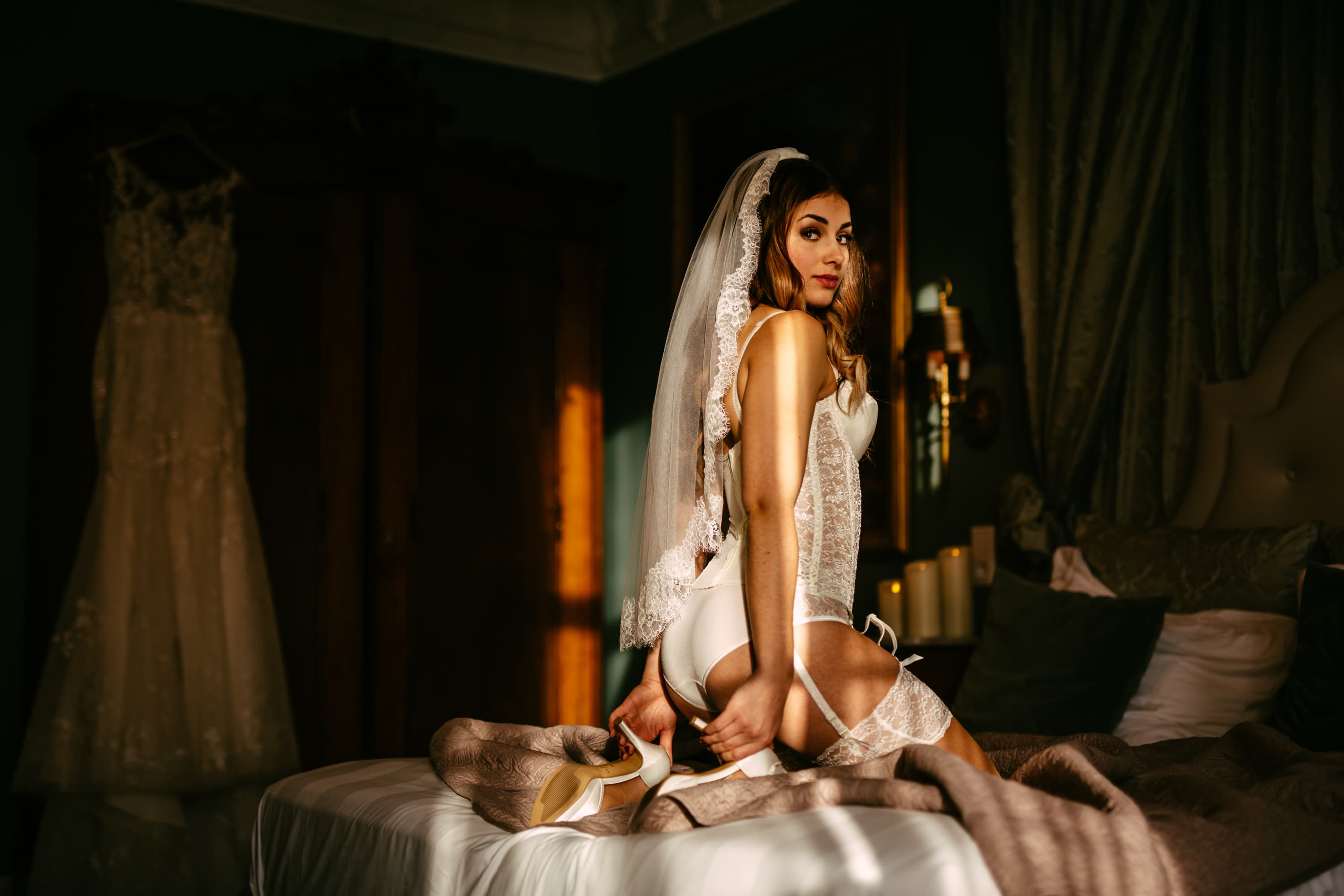 Een bruid in een trouwjurk die zich voordeed op een bed.