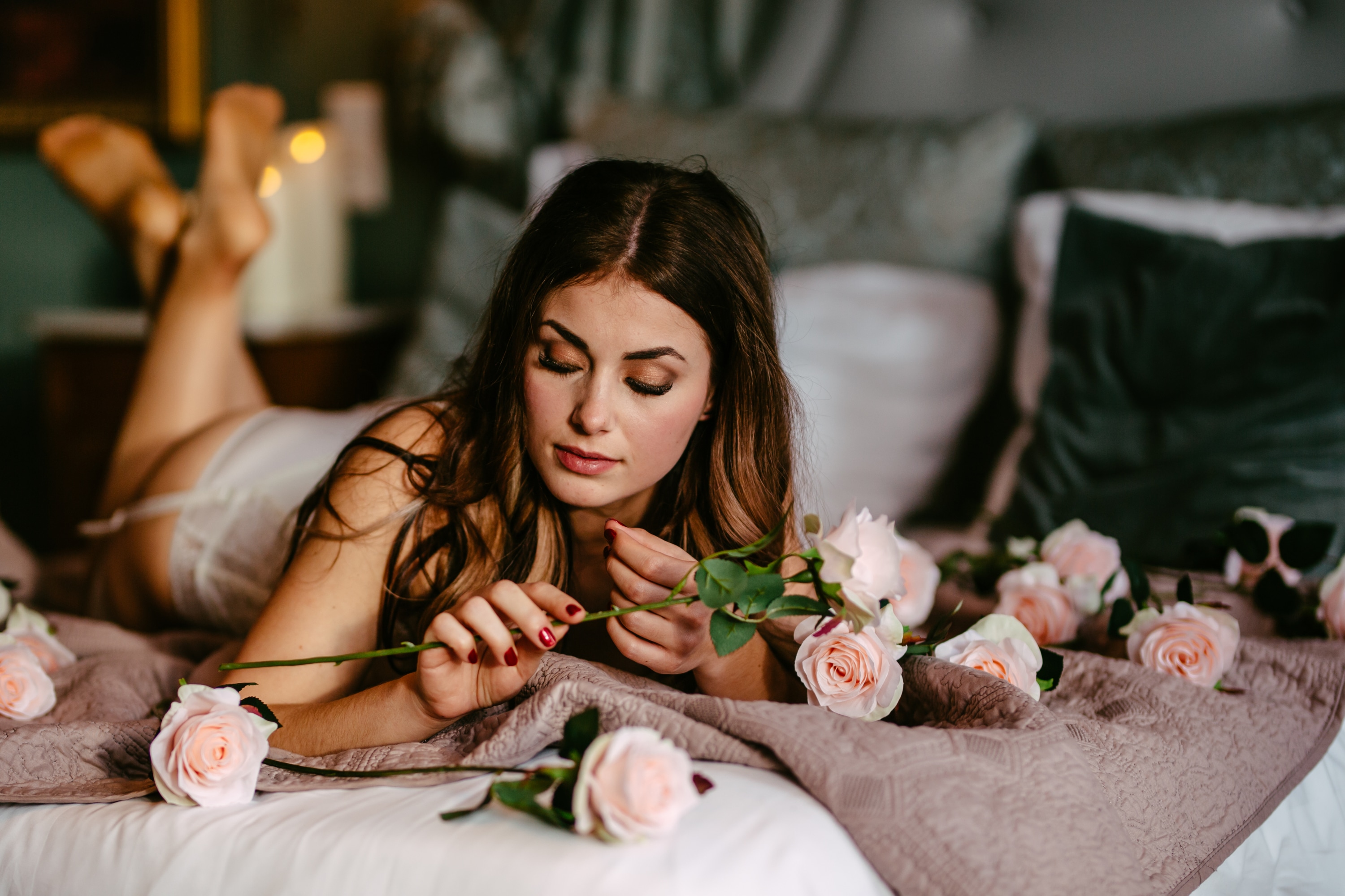 Een vrouw liggend op een bed met rozen.