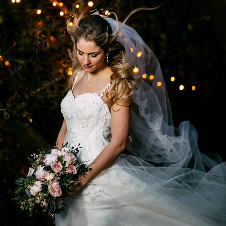 A bride in a beautiful wedding dress gracefully holding a bouquet, captured by a talented wedding photographer. Share this magical moment on Instagram.