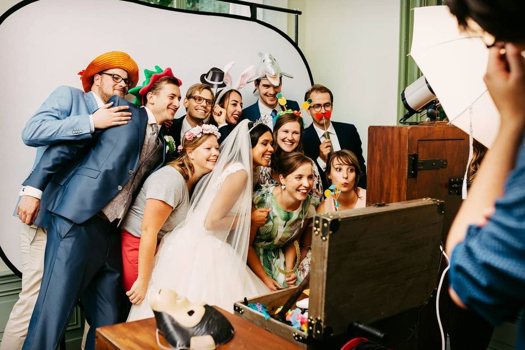 Een groep mensen poseert voor een foto in een photobooth, vastgelegd door een Instagram-trouwfotograaf.