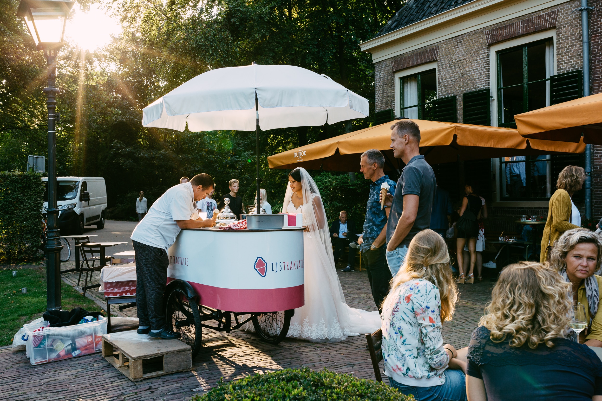 Een groep mensen genietend van een ijsje bij een karretje tijdens trouwfotografie.