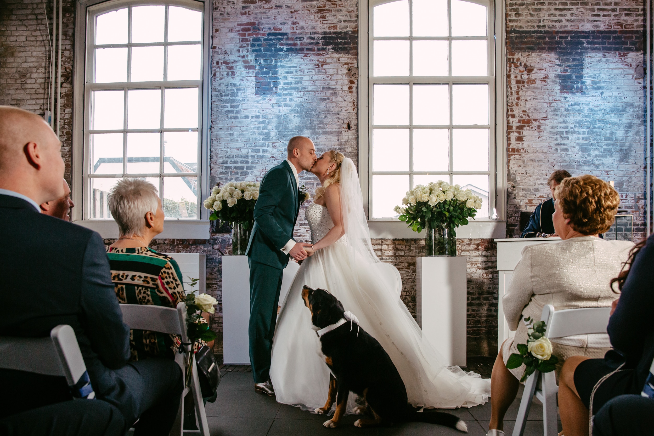 A bride and groom share a loving kiss during their wedding ceremony at one of South Holland's beautiful wedding venues.