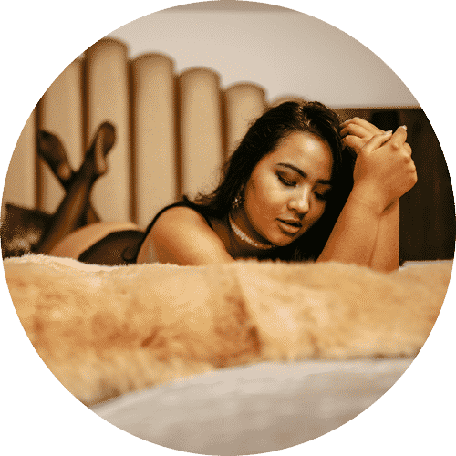 Een vrouw in lingerie die op een bed ligt.
