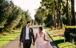 Trouwfoto's van een bruid en bruidegom die over een pad lopen.