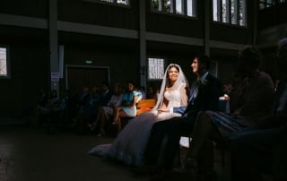 Een bruid en bruidegom zitten in een kerk tijdens hun Trouwfotos-ceremonie.
