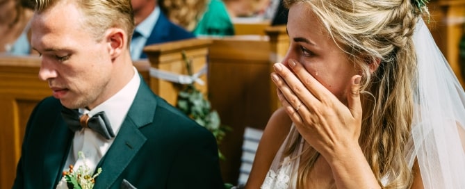 Wedding photography captures the emotional moment when a bride and groom are moved to tears during their wedding ceremony.