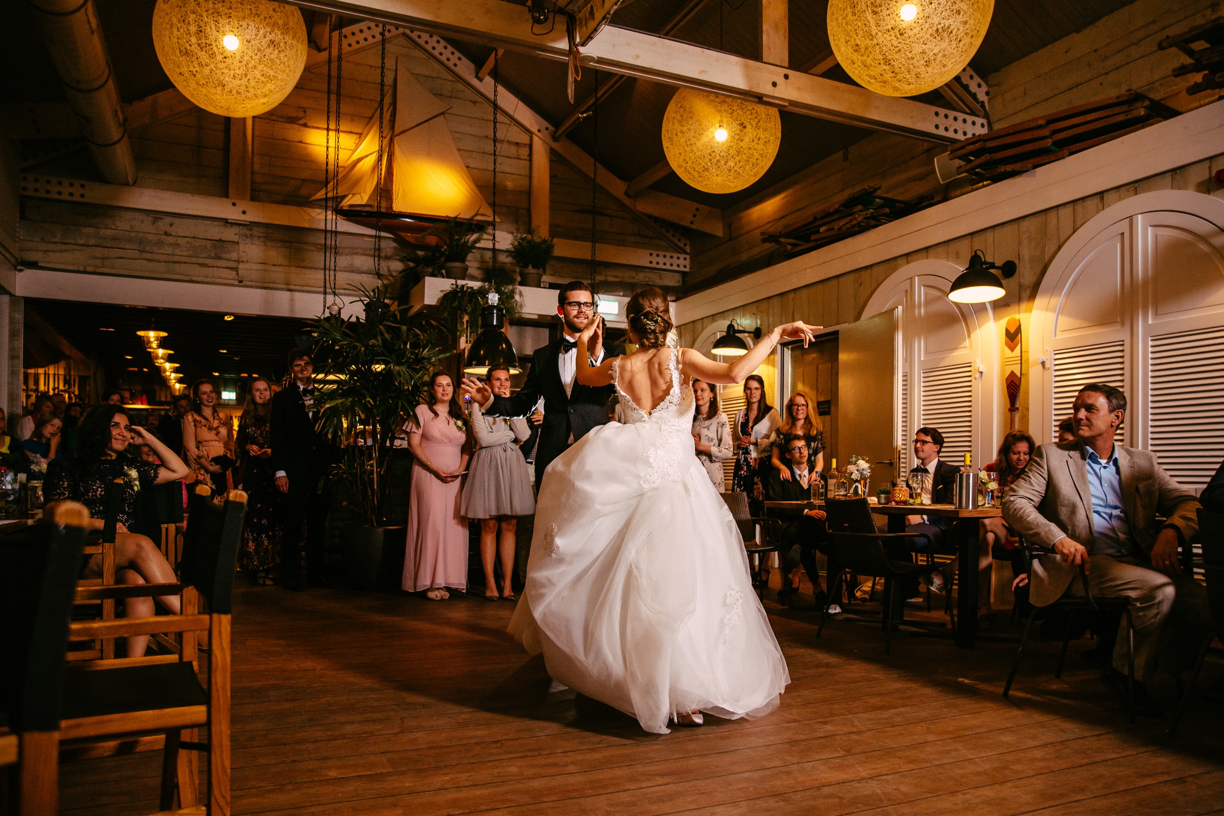 A bride and groom gracefully performing their opening dance to the tune of romantic songs during their wedding reception.