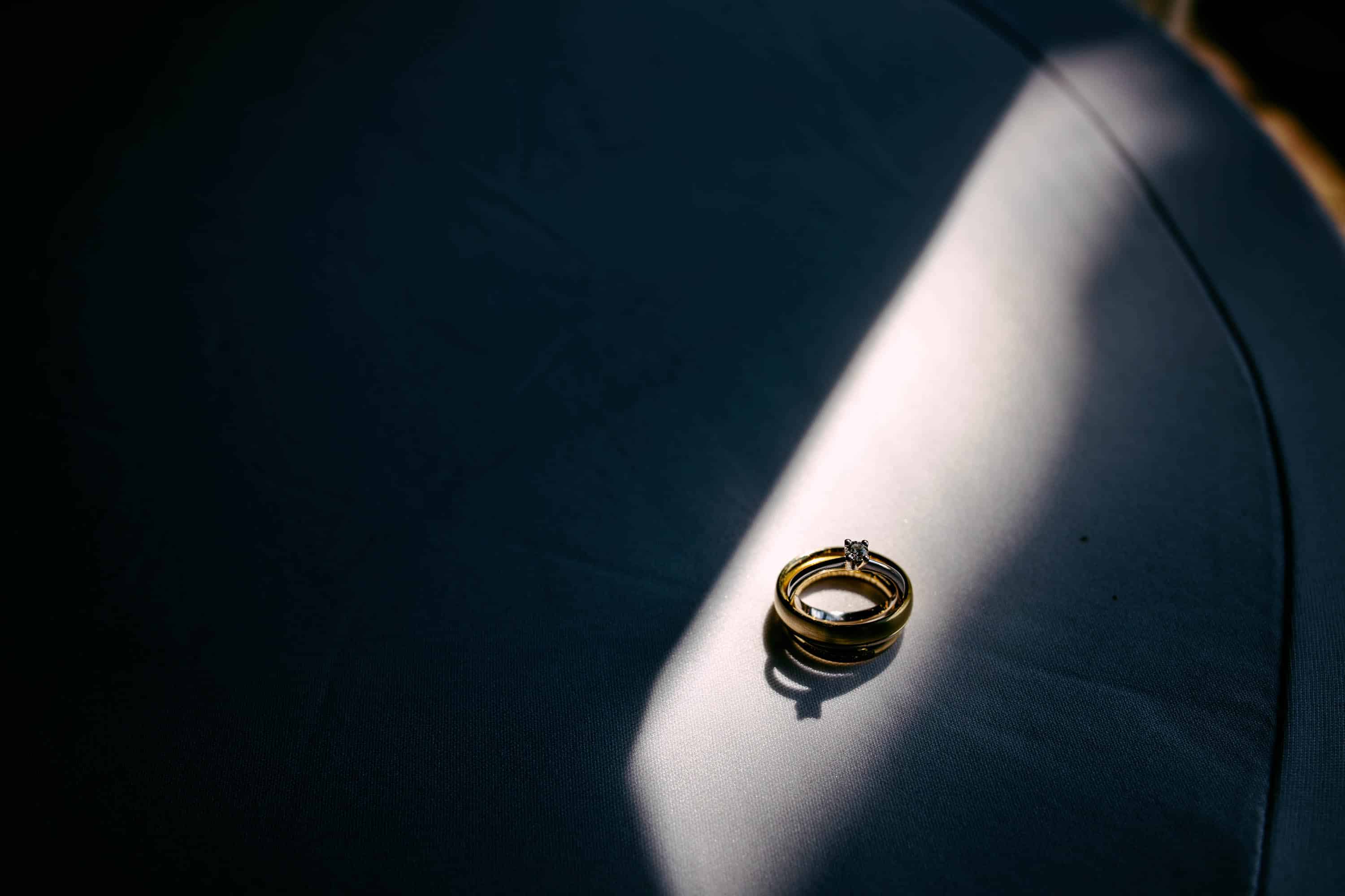 On a bed lies a wedding ring.