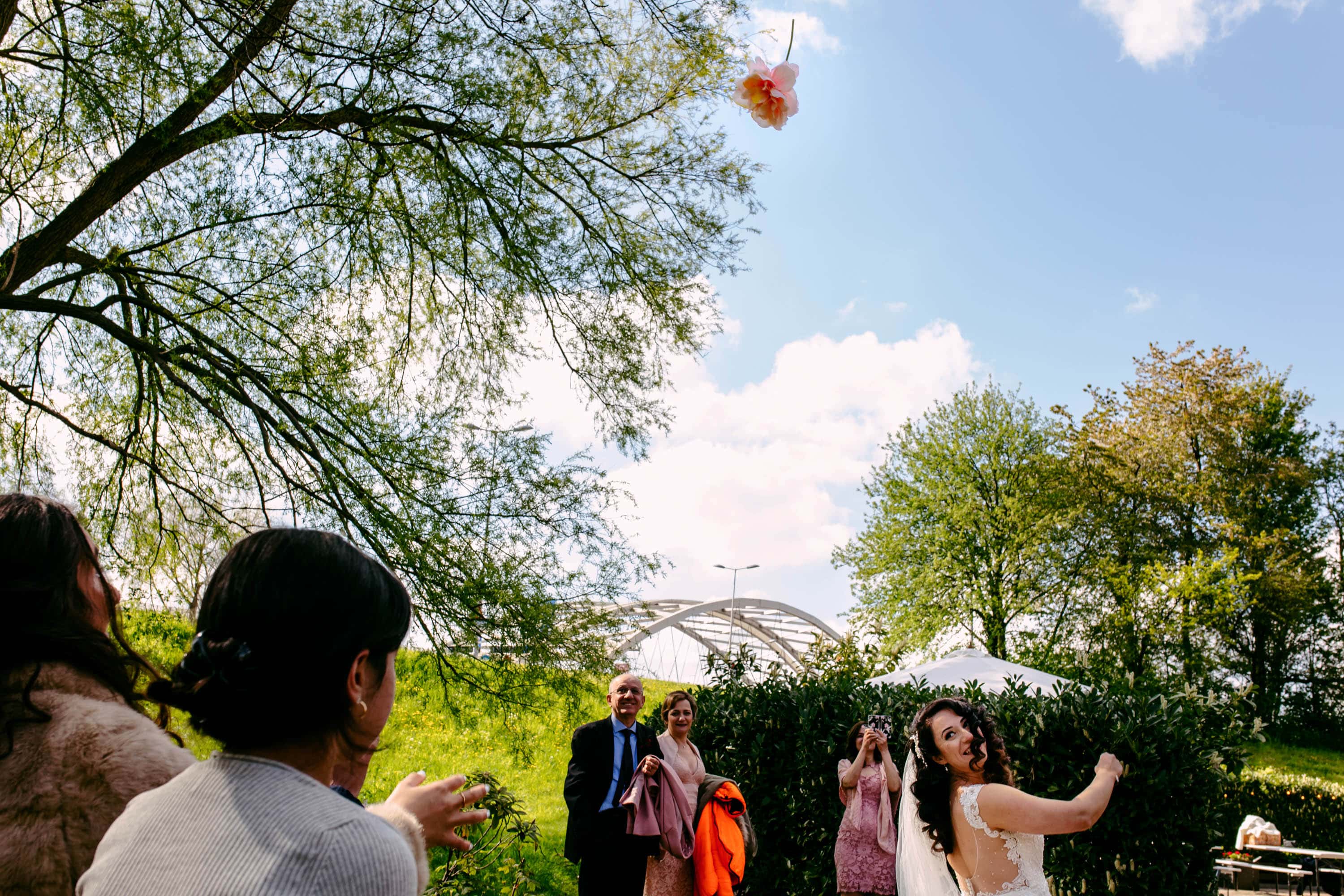A bride and groom toss a kite in the air.