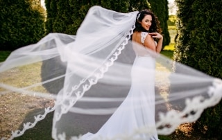 Een trouwfotografie bruid met haar sluier wapperend in de wind.