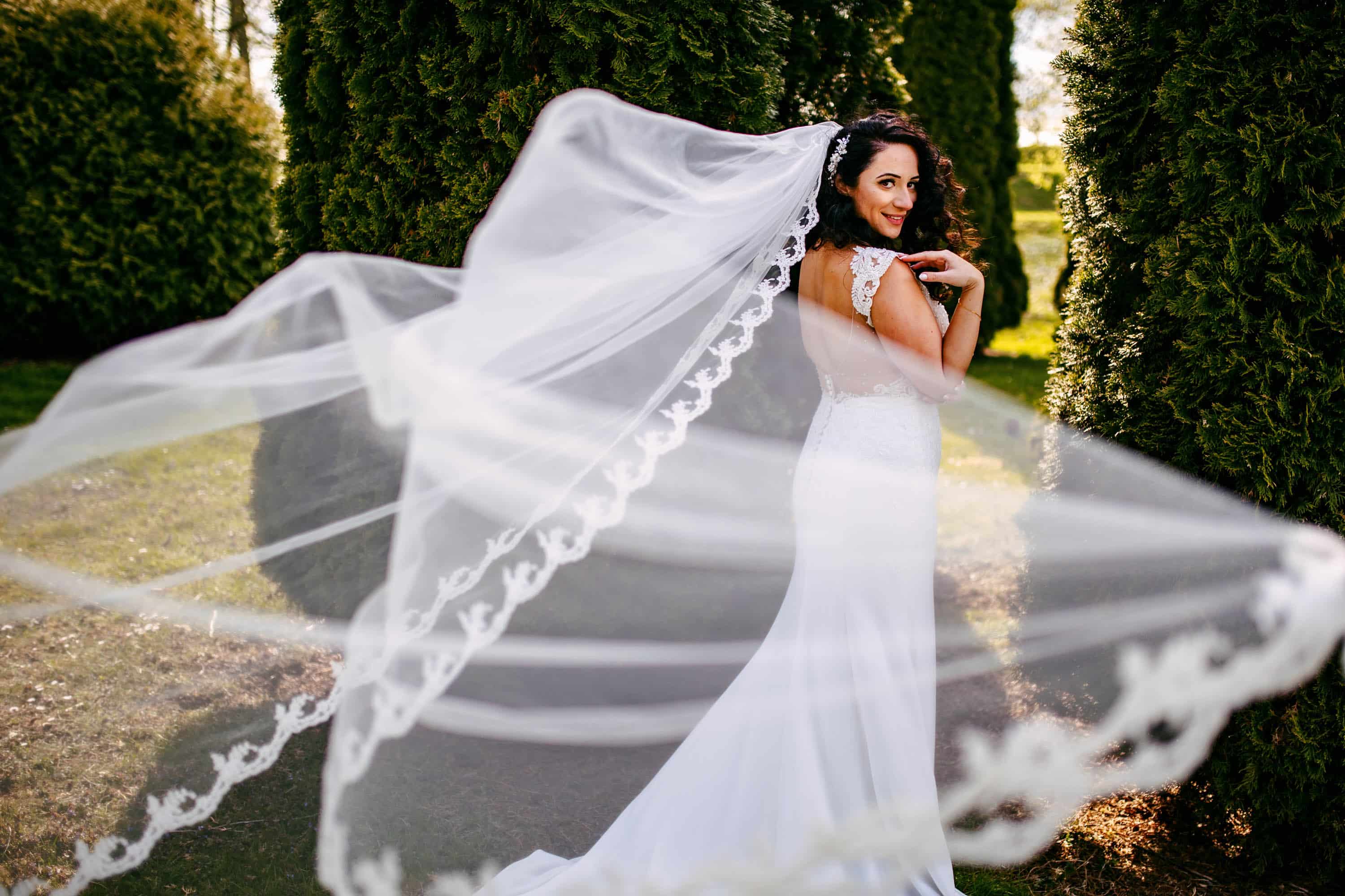 A bride with her veil flapping in the wind.