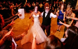 Een bruid en bruidegom die elegant over de dansvloer lopen en bijzondere trouwfoto's maken.
