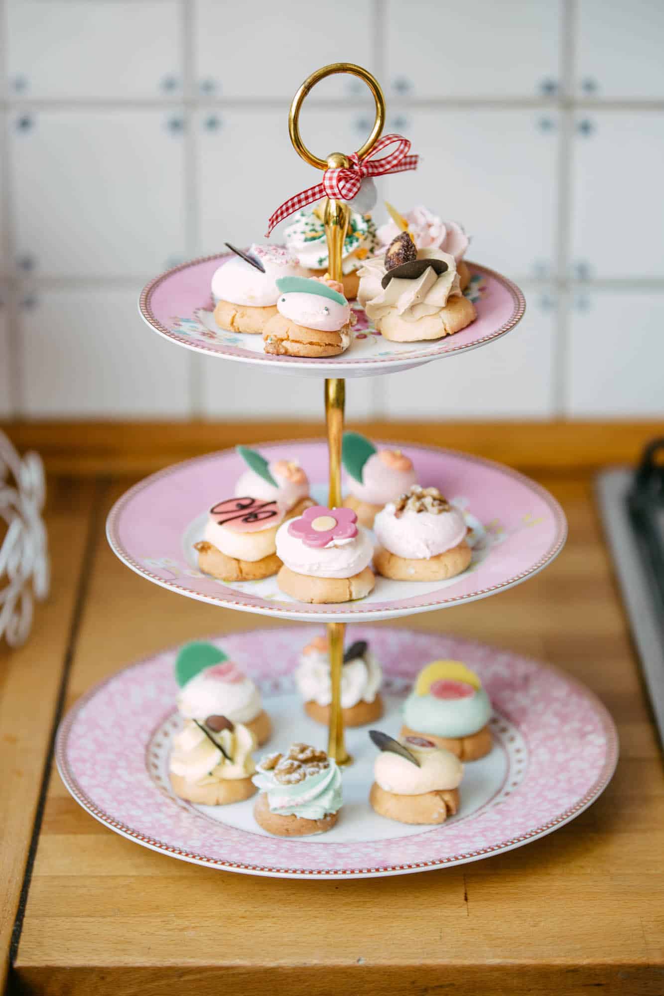 A three-tier cake tray decorated with delicious cupcakes, perfect for displaying beautiful wedding cakes.