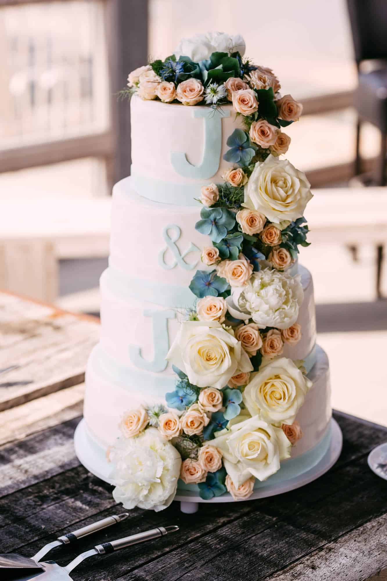 Light blue wedding cake with flowers and initials