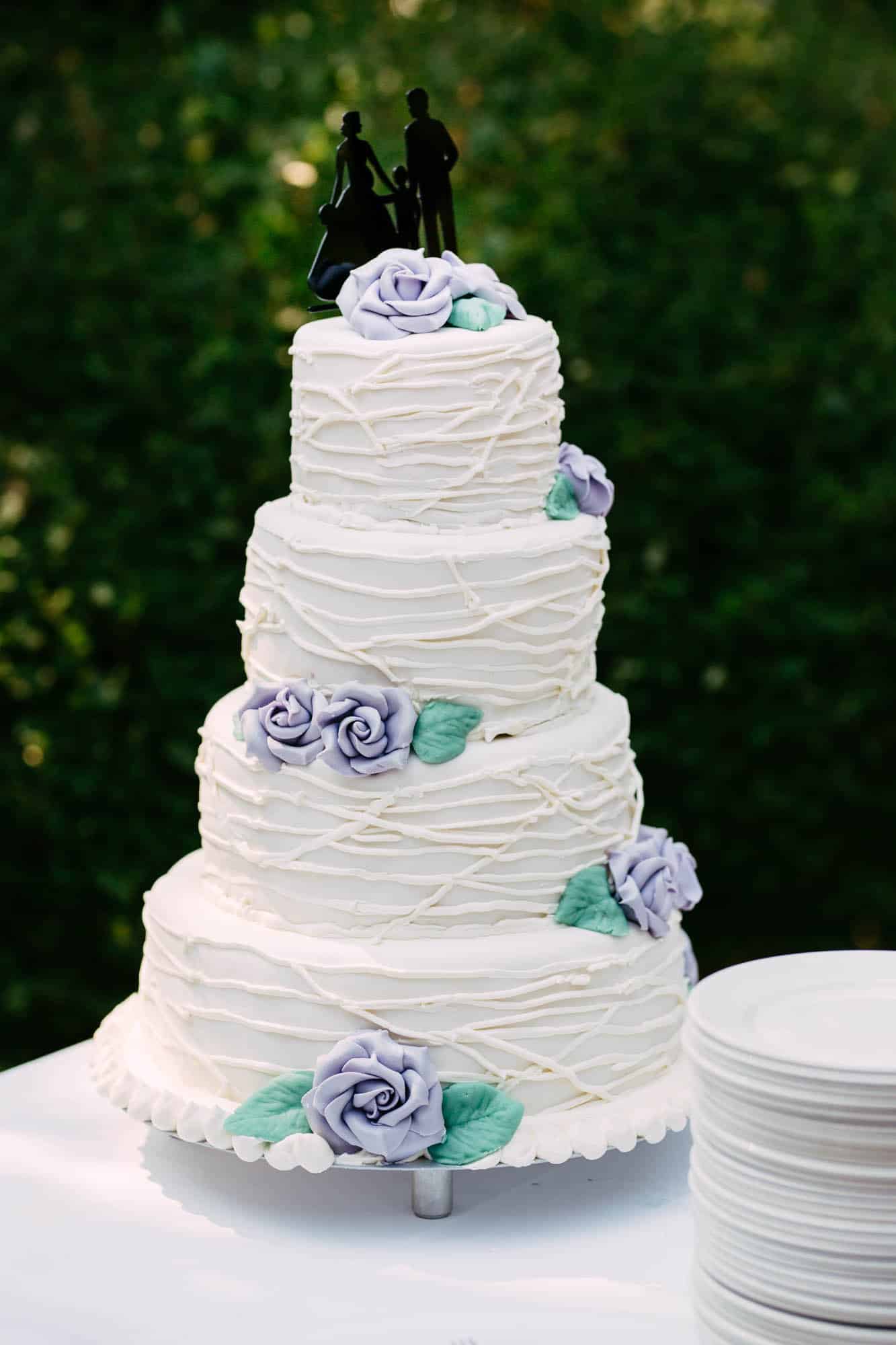 Witte taart met gezin en lavendel kleurige rozen