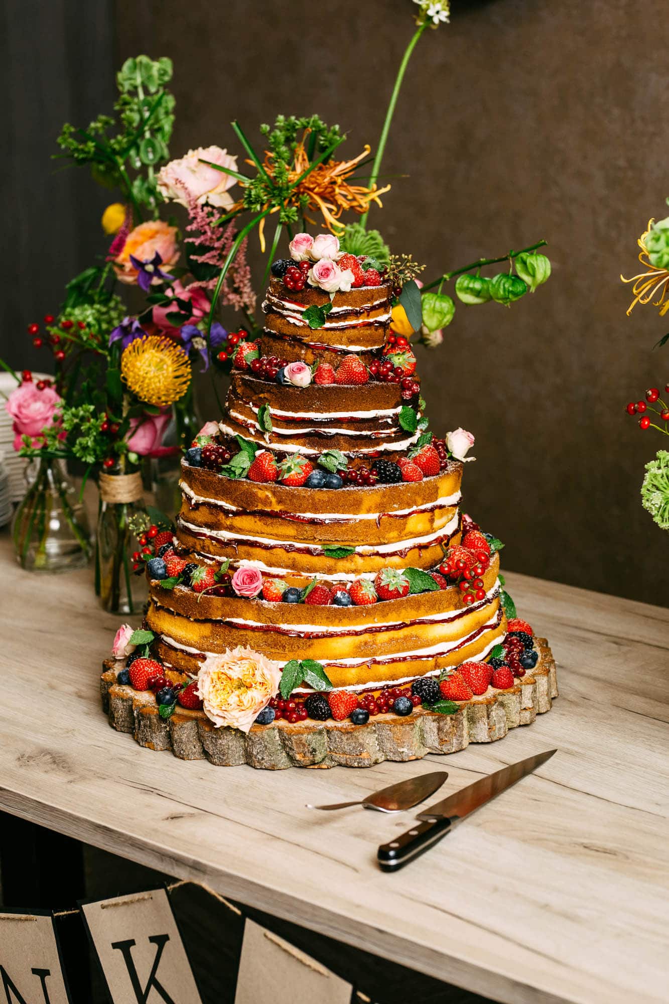 A wedding cake with lots of fruit on it.