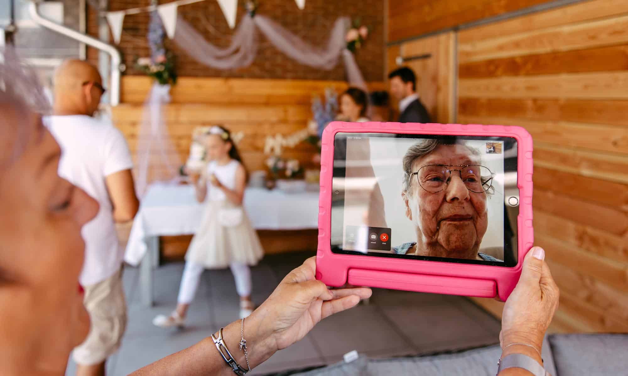 A woman captures a precious moment of her granddaughter on an iPad.