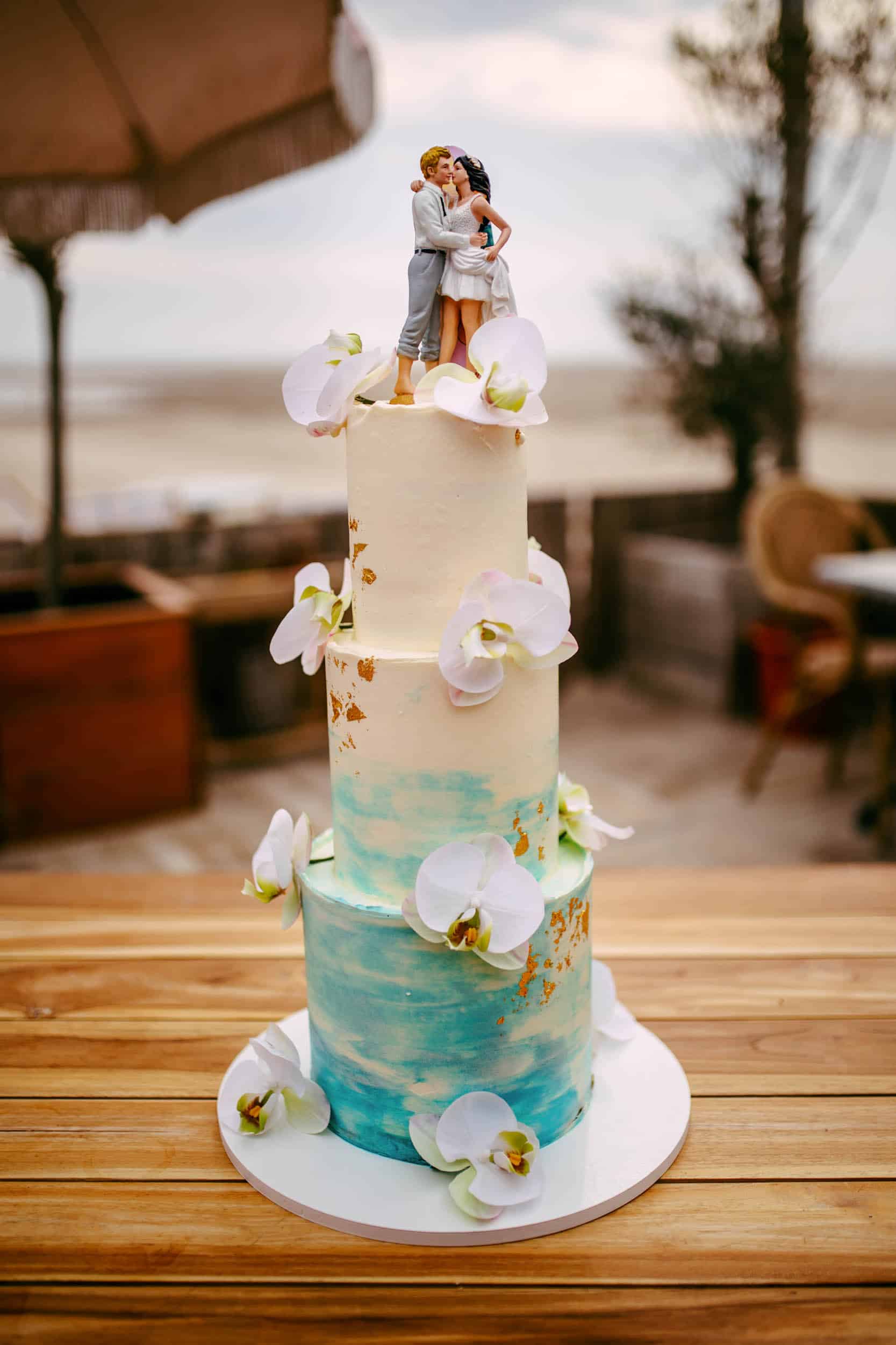 Description: A wedding cake with a couple on it.