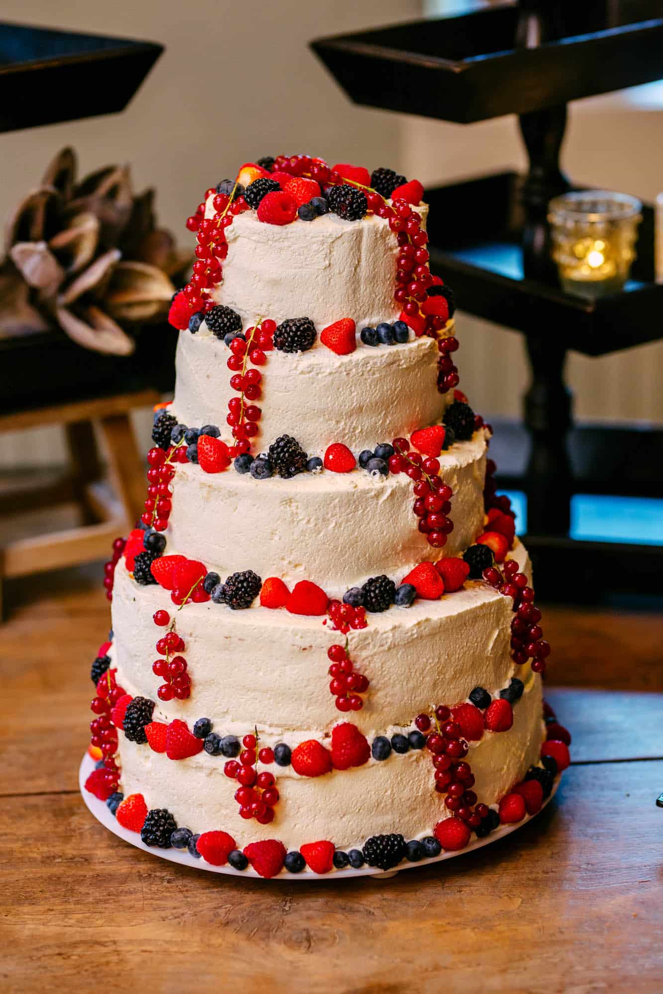 A wedding cake with three layers and berries on top, perfect for wedding cakes.