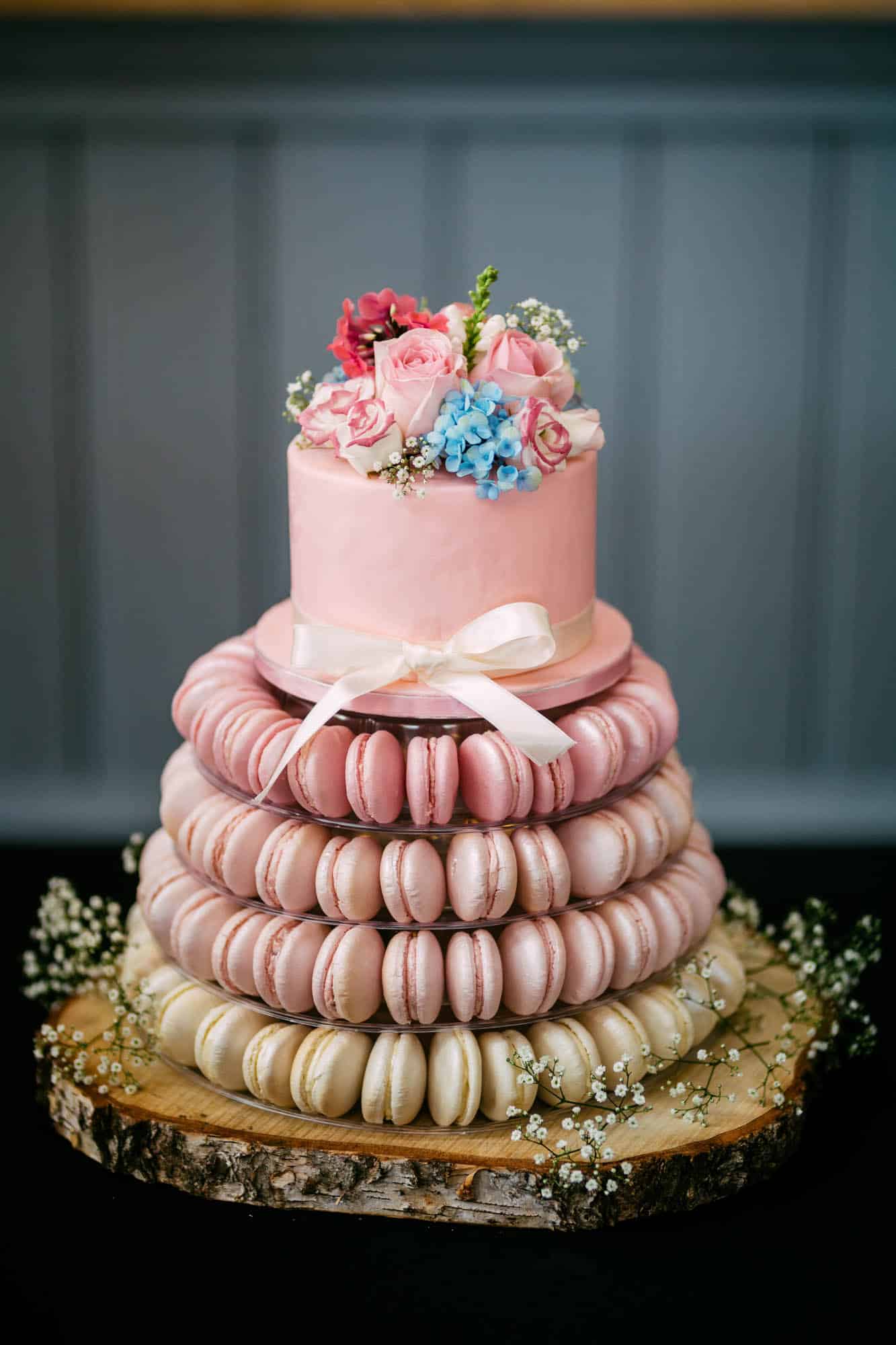 A wedding cake with macaroons on top.