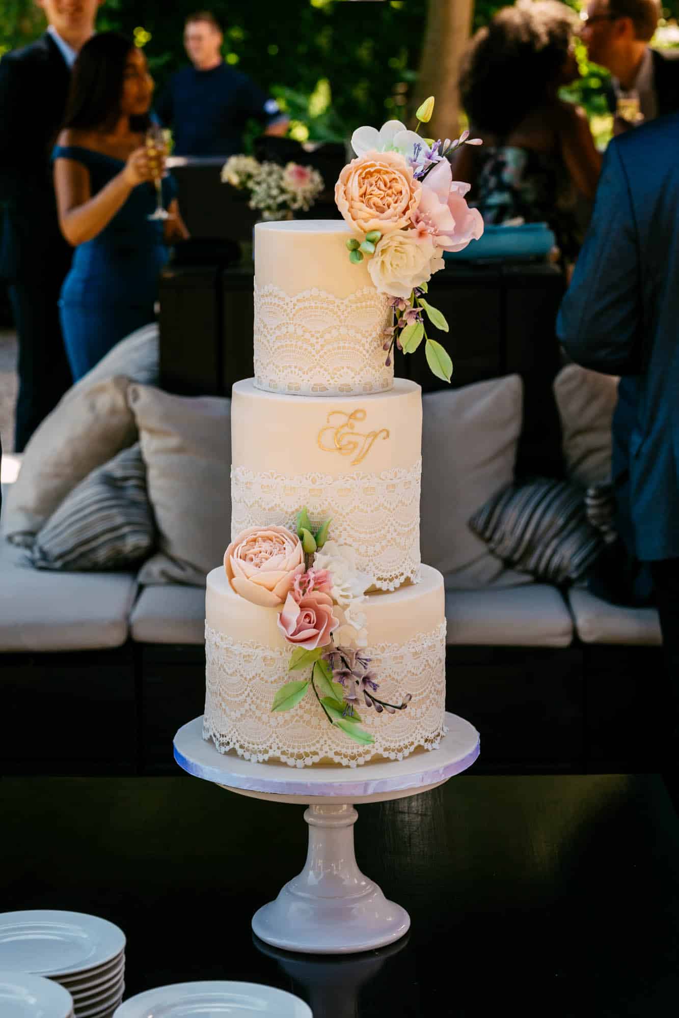 A three-tiered wedding cake stands on a table.