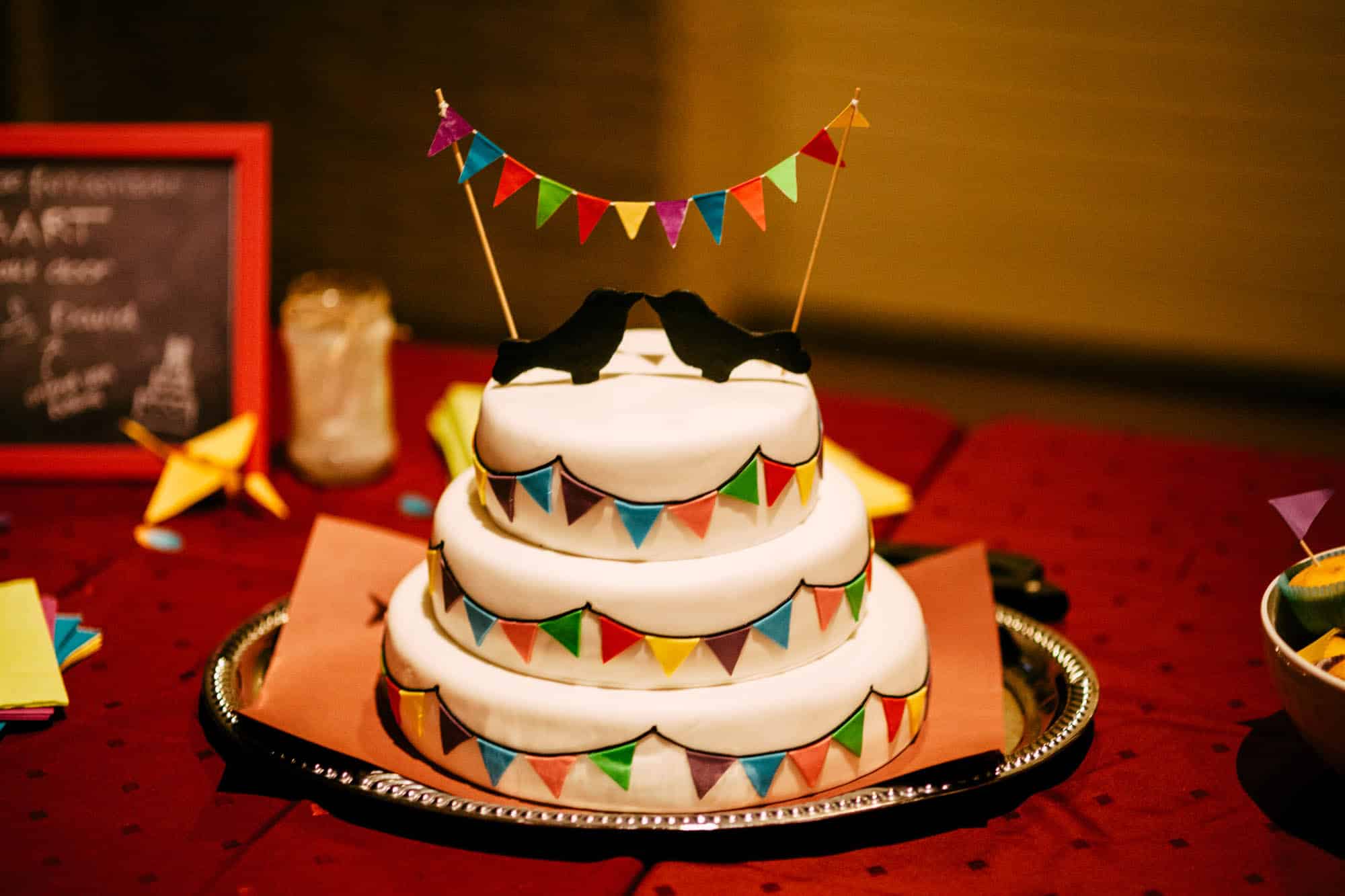 Een Budget Bruiloft drielaagse taart met slinger er bovenop voor wie op zoek is naar Goedkoop trouwen.