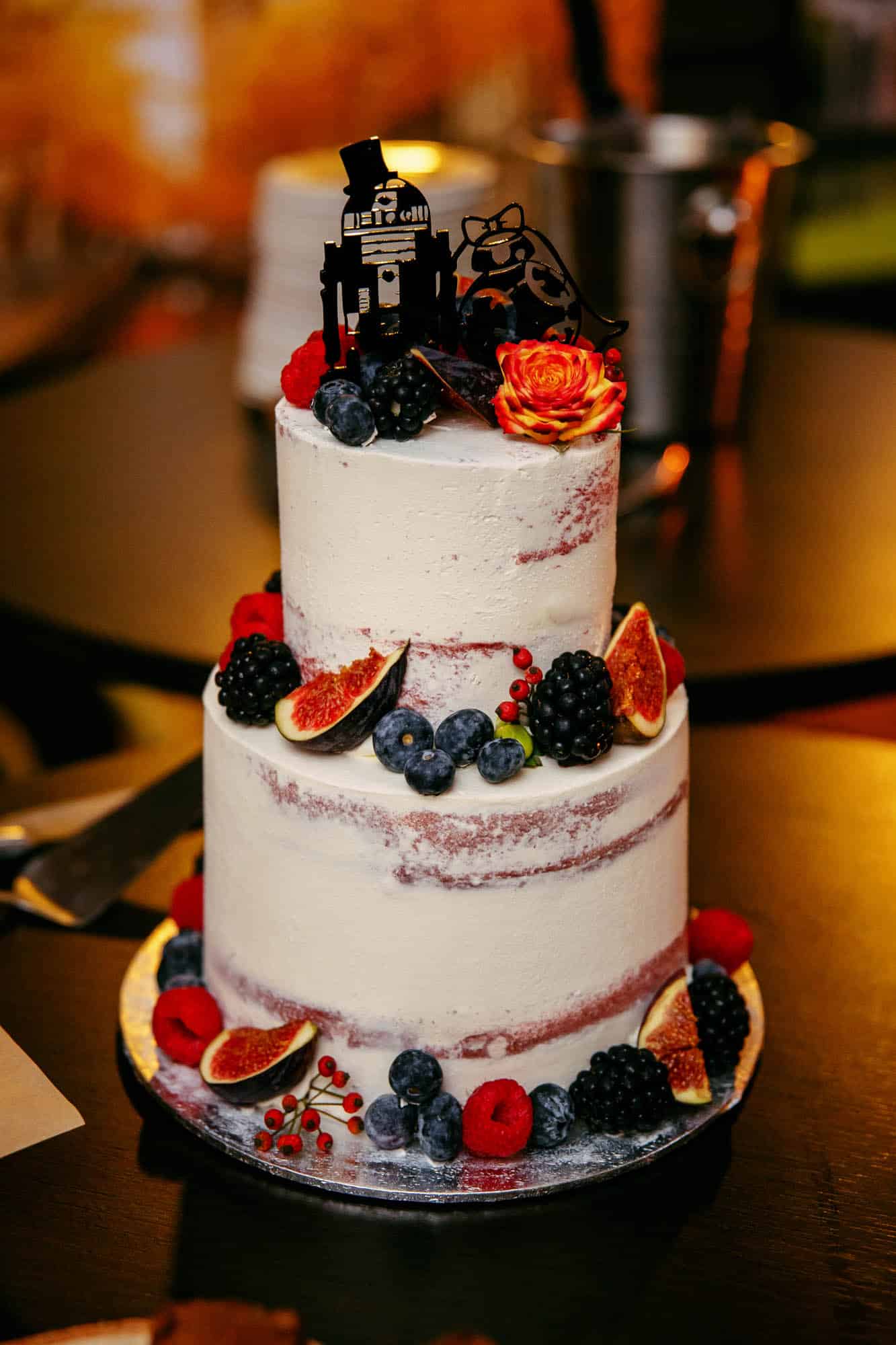A wedding cake with berries and fruit on top.