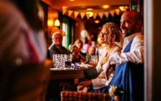 Een bruid en bruid zitten aan een tafel in een restaurant, terwijl ze gelukwensen tijdens hun huwelijk.