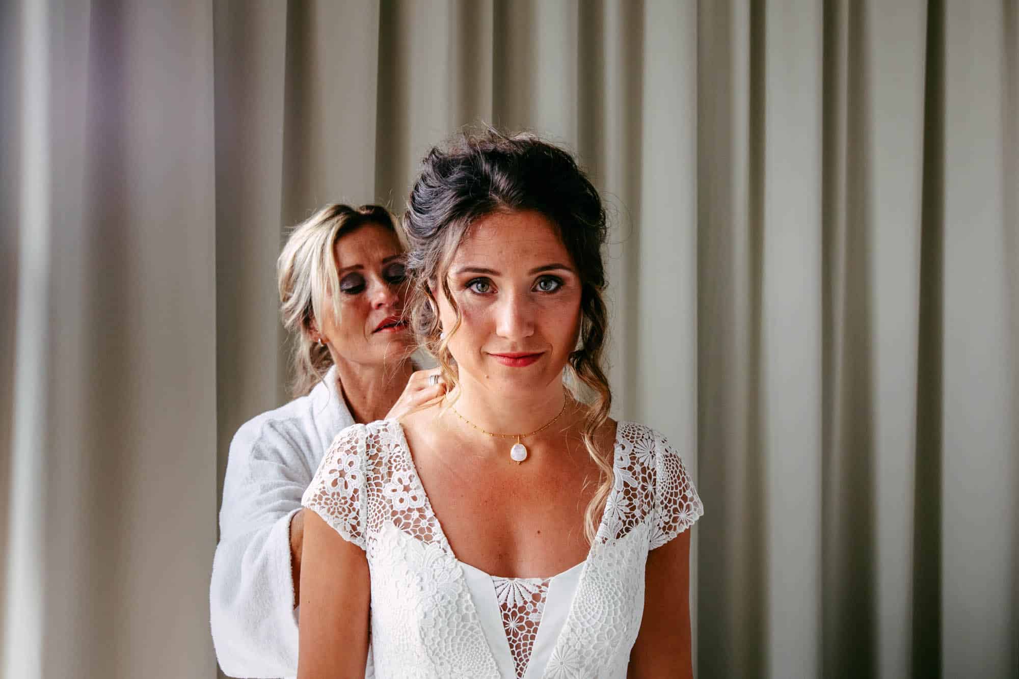 A bride gets ready for her wedding in her bohemian wedding dress.