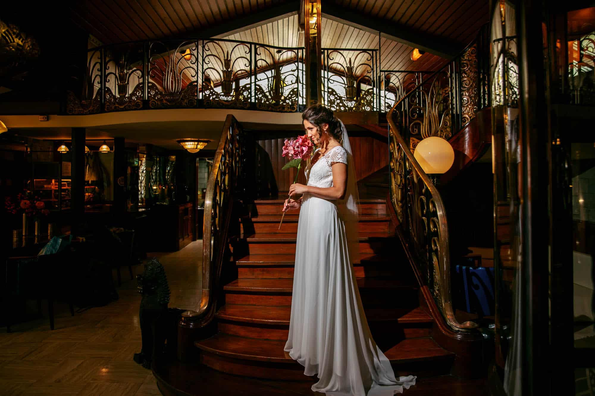 A Bohemian bride standing on the steps of a restaurant.