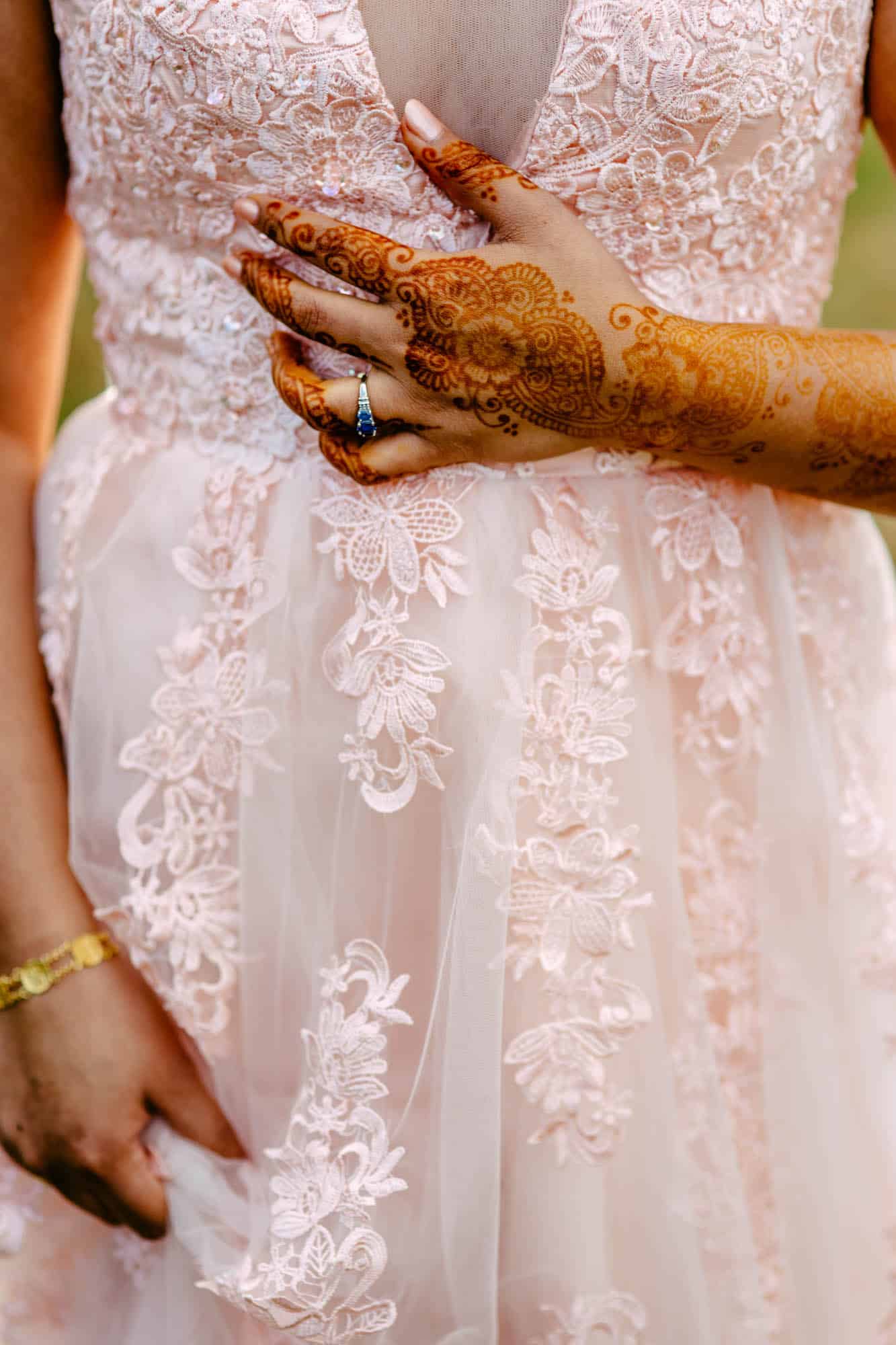 A Bohemian bride in a pink dress with henna on her hands.