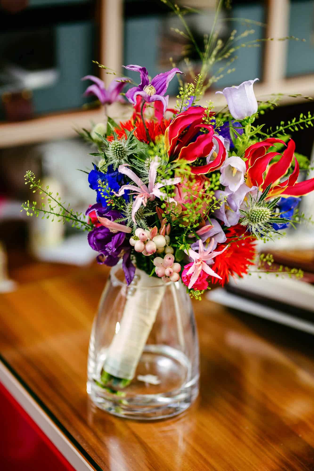 On a table is a wedding bouquet of colourful flowers.