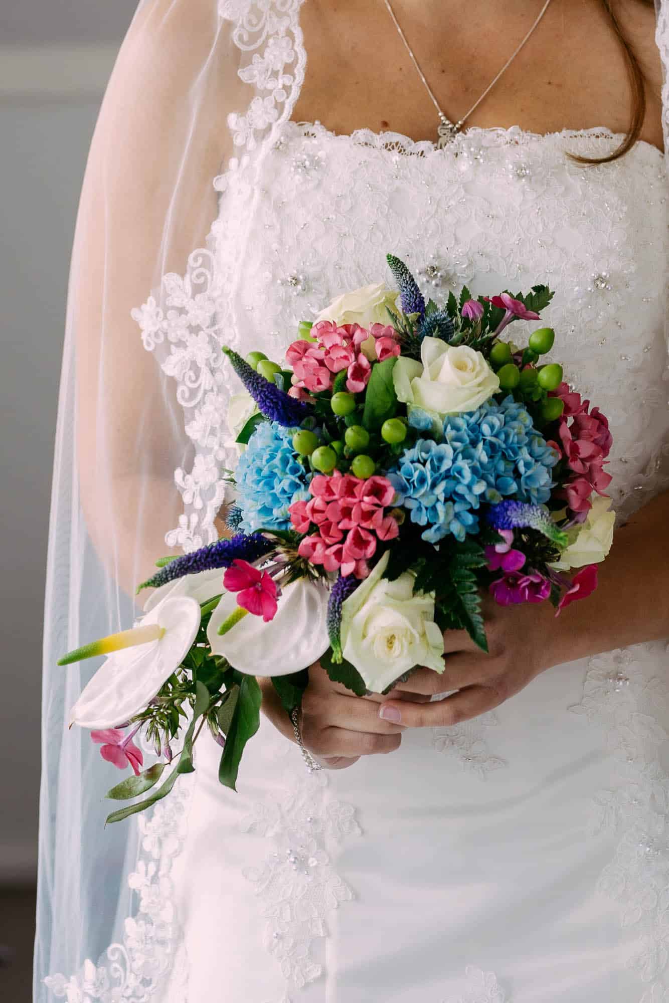 A bride with a wedding bouquet full of colourful flowers.