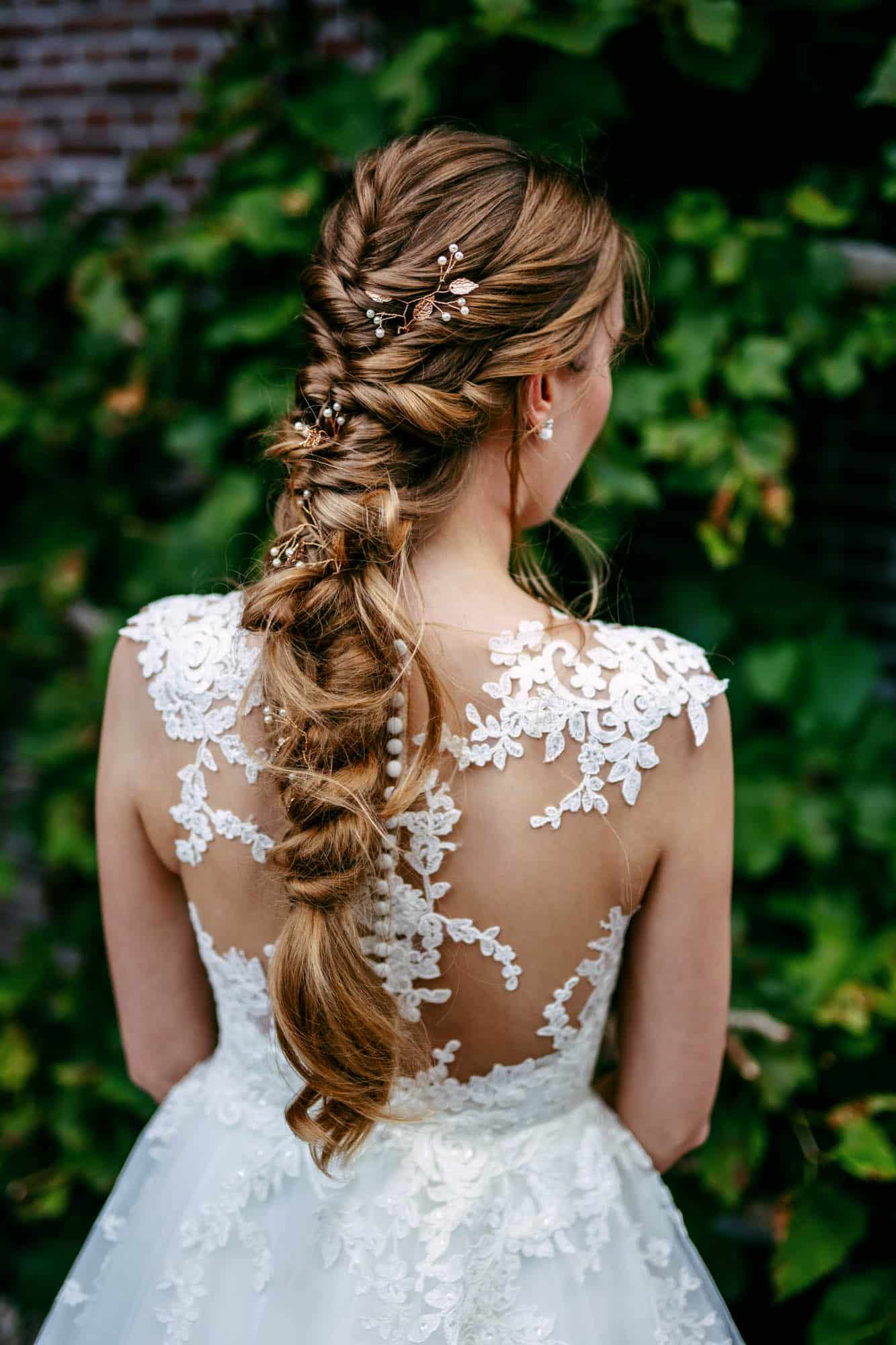 A bride in a white wedding dress with a braided hairstyle with beautiful bridal hairstyles.