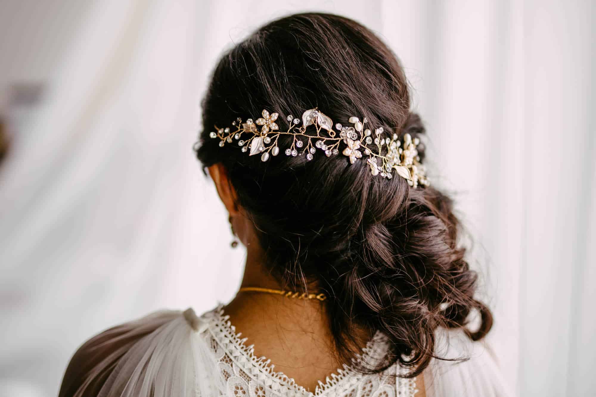 A bride in a white dress with a floral hair comb, with beautiful bridal hairstyles.